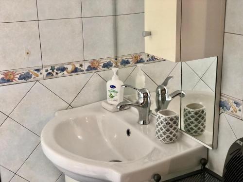 lavabo blanco en el baño con espejo en Casa Palazzo Civitanova, en Civitanova del Sannio