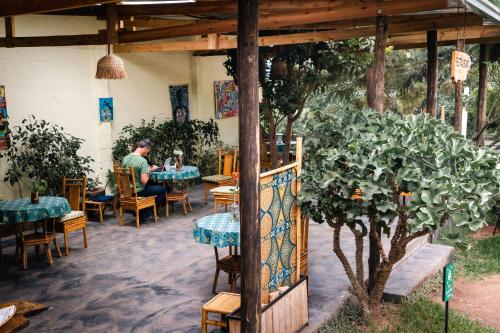 Ein Mann, der an einem Tisch in einem Restaurant sitzt. in der Unterkunft Tea House BNB in Kigali