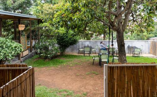 a person sitting at a table under a tree at Tea House BNB in Kigali