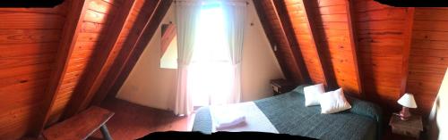 1 dormitorio con cama y ventana en Cabañas Ayres del cerro en Merlo