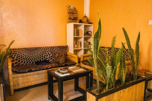 a living room with two couches and a table with plants at Tea House BNB in Kigali