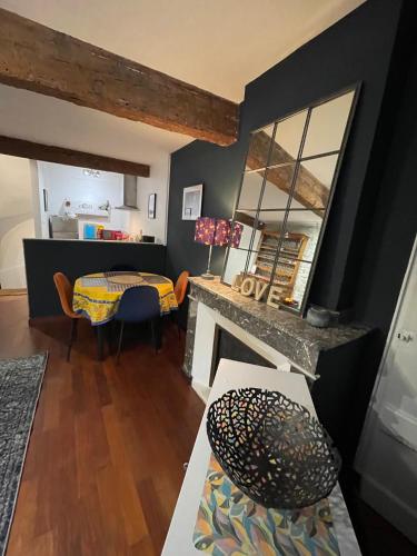 a living room with a fireplace and a table at la maison des chapeliers in Carcassonne