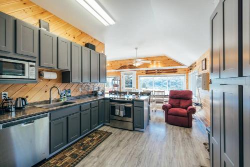 una cocina con armarios verdes y una silla roja en Lakefront Stunning Home, only 30 min to Sugarloaf! en New Portland
