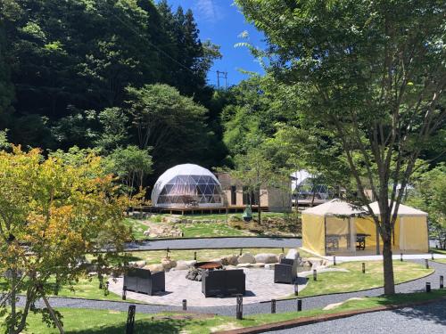 a garden with a domed greenhouse and a tent at mokki STARDUST GLAMPING in Achi