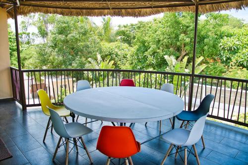 a table and chairs in a room with a balcony at RESIDENCE SAPHIR in Mahajanga