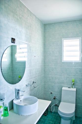 a bathroom with a sink and a toilet and a mirror at RESIDENCE SAPHIR in Mahajanga