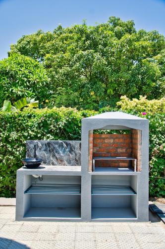 a white bench sitting in front of a bush at RESIDENCE SAPHIR in Mahajanga