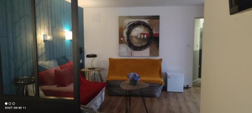 a living room with a chair and a table at Hotel Le Petit Billot in Vitré