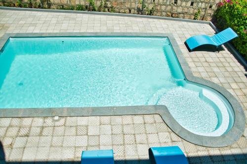 a swimming pool with two blue chairs in it at RESIDENCE SAPHIR in Mahajanga