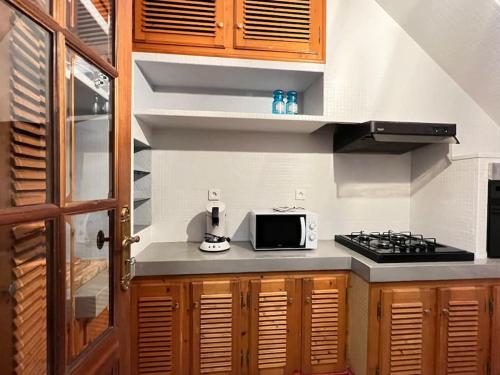 une petite cuisine avec un micro-ondes et une cuisinière dans l'établissement Quartier piéton. T3 65m2. 2 chambres. 5 personnes., à Cauterets