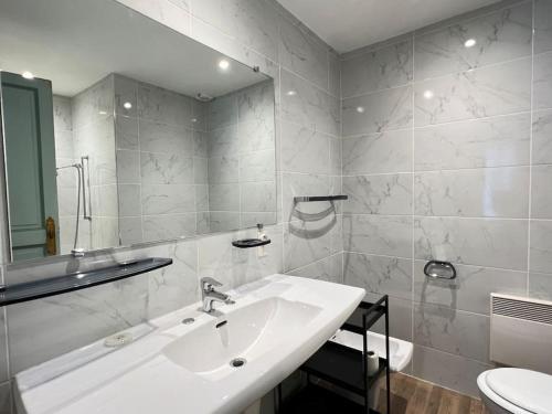 une salle de bain blanche avec un lavabo et des toilettes dans l'établissement Quartier piéton. T3 65m2. 2 chambres. 5 personnes., à Cauterets