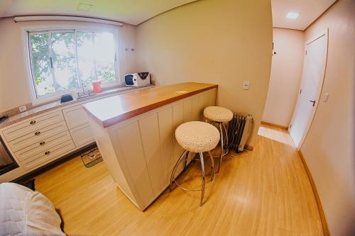 a kitchen with a counter and stools in a room at Sítio Crescer in Garibaldi