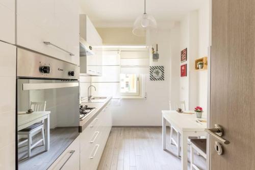 a white kitchen with white counters and a stove top oven at la casetta dei sogni in Rome