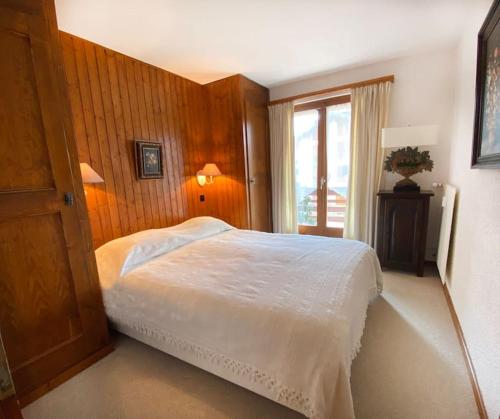 - une chambre avec un lit blanc et une fenêtre dans l'établissement Ski in/out 150 m, 2 chambres , 6 personnes., à Verbier