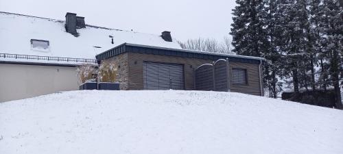 a pile of snow in front of a house at Ferienwohnung Kessler's Eifeldomizil in Auw