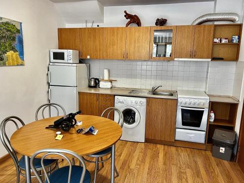 a kitchen with a wooden table and a table and chairs at Christina Apartment in Laplandia in Pamporovo
