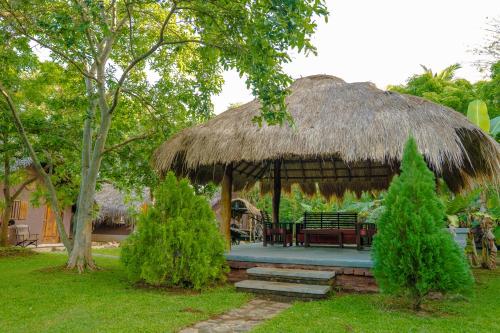 a gazebo with a bench and a grass roof at Gaga Bees Yala in Tissamaharama