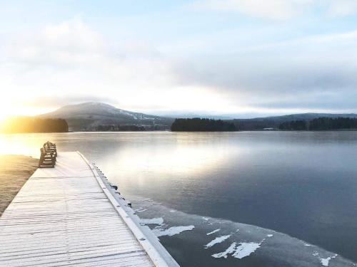 a wooden dock with a bench on a lake at 4 person holiday home in Sollerön-By Traum in Sollerön