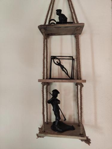 a shelf with a figurine of a man and a cat on it at Allotjaments Cal Llarg in Molló