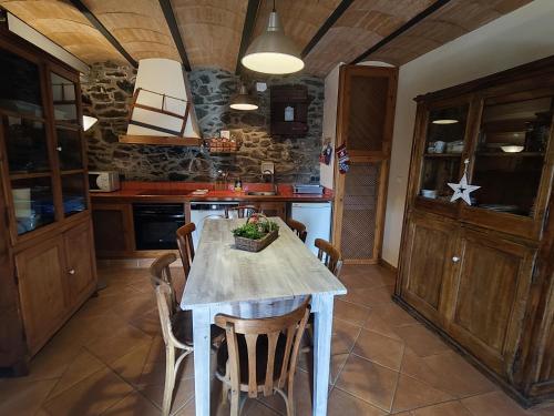 a kitchen with a table and chairs in a room at Allotjaments Cal Llarg in Molló