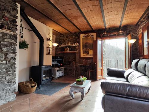 a living room with a couch and a fireplace at Allotjaments Cal Llarg in Molló