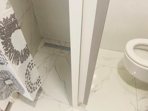 a bathroom with a toilet and a marble floor at Hostel OT in Split