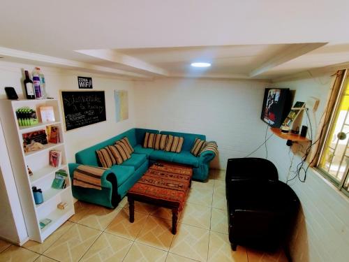 a living room with a blue couch and a coffee table at Backpackers House - Near The Airport in Santiago