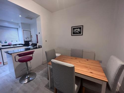 uma sala de jantar com uma mesa de madeira e cadeiras em Amicable Double Bedroom in Manchester in shared house em Ashton-under-Lyne