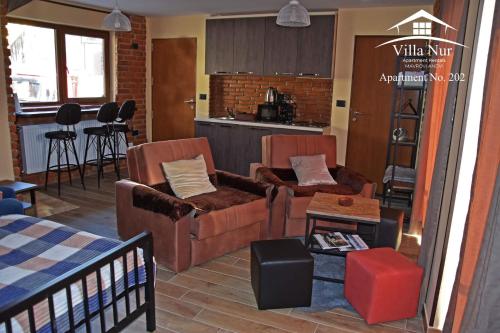 a living room with two couches and a kitchen at Villa Nur - Lake View Apartaments in Mavrovi Anovi