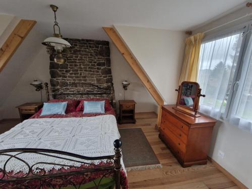 - une chambre avec un lit et un mur en briques dans l'établissement La Bannerie, à Mesnil-Clinchamps