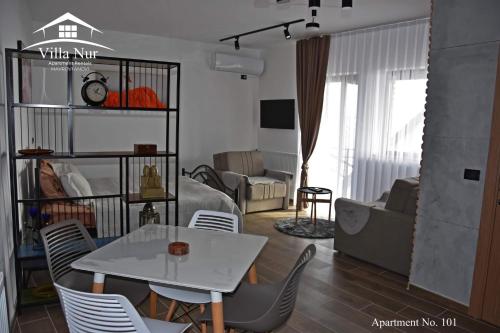 een woonkamer met een witte tafel en stoelen bij Villa Nur - Lake View Apartaments in Mavrovi Anovi