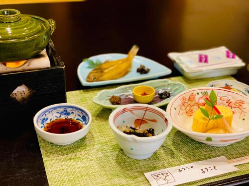 una mesa con tazones de comida en una mesa en Iwayu en Misasa