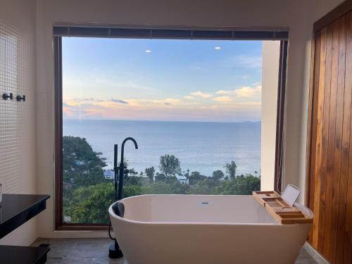 a bath tub in a bathroom with a large window at High Life Villas in Salad Beach