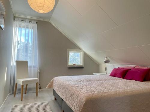 a bedroom with a bed with pink pillows and a window at Björkholm - Villa in Målilla in Målilla