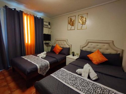 a bedroom with two beds with orange pillows at O Boutique Hotel (Free Breakfast) in Tagaytay