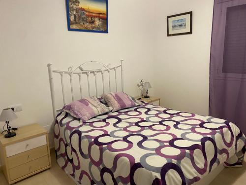 1 dormitorio con 1 cama con edredón blanco y negro en Mirador de Turre, en Turre