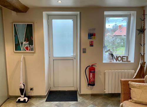 ein Wohnzimmer mit einer Tür und einem Hydranten in der Unterkunft Maison indépendante, domaine VICHY LA TOUR in Abrest