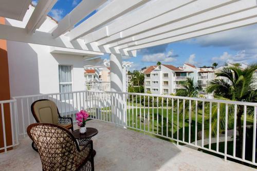 a balcony with chairs and a view of a building at Ocean Views & Private Beach! Luxury 4BDR Getaway in Punta Cana