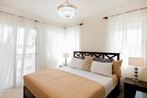 1 dormitorio con 1 cama grande y cortinas blancas en The Ultimate Escape Unpack Relax Enjoy en Punta Cana