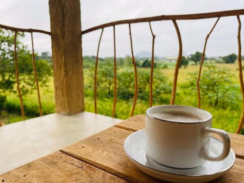 a cup of coffee sitting on top of a table at Rock Shade Chalet- Sigiriya in Sigiriya