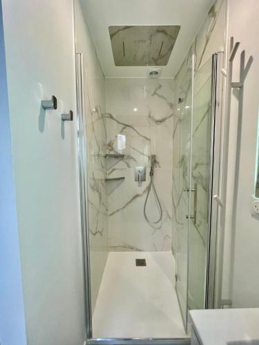 une salle de bain avec une douche avec une porte vitrée dans l'établissement Designer Apartment Tour Saint-Jacques - 1BR 4P, à Paris