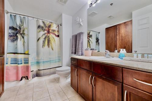 a bathroom with a sink and a toilet and a shower curtain at Luxurious 4 Bedroom Condo! Gulf Views! Sleeps 10 & Easy Beach Access! by Dolce Vita Getaways PCB in Panama City Beach