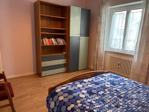 a bedroom with a bed and a book shelf at Appartamento Vanoi nel cuore verde del Trentino in Canale San Bovo