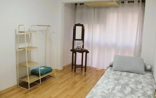 a bedroom with a bed and a mirror and a shelf at Al pie del Camarín con parking gratis in Jaén