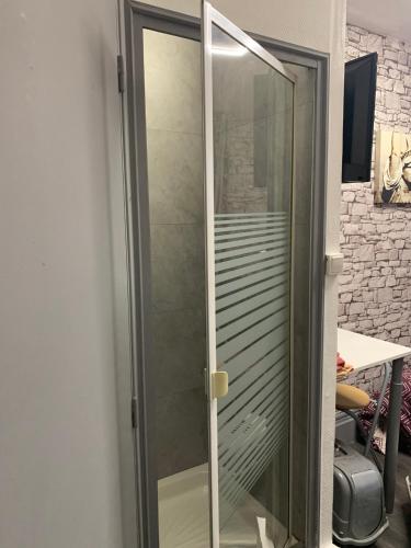 Cette chambre comprend une porte en verre et un bureau. dans l'établissement Au Coeur De Lyon, à Lyon