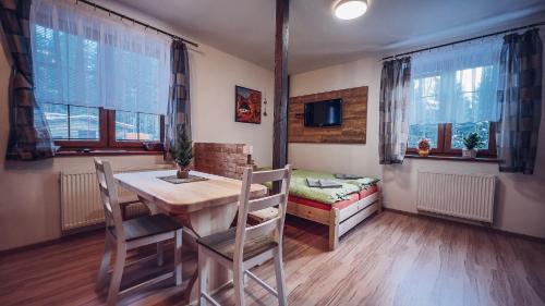 a dining room with a table and chairs and a couch at Apartmány Domino in Železná Ruda