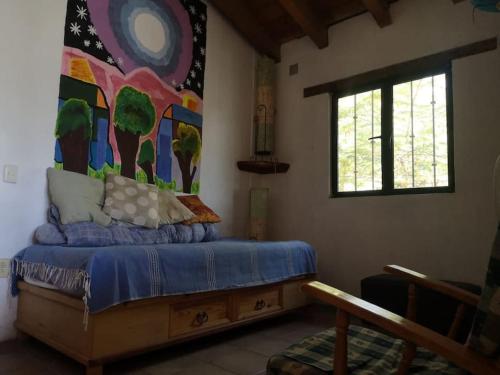 1 dormitorio con 1 cama con una pintura en la pared en La casa de Buenavista. 