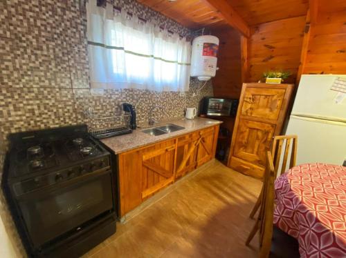 uma cozinha com um fogão, um lavatório e um frigorífico em Alpina La Luna em Valle Hermoso