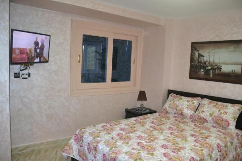 a bedroom with a bed and a window at Downtown Apartment in Rabat