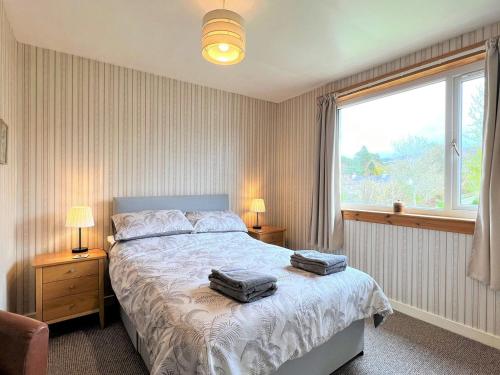 a bedroom with a bed with two bags on it at Westerdale in Fort Augustus